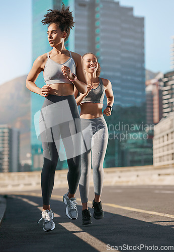 Image of Fitness, exercise and friends running in the city together for an intense cardio workout in street. Sports, athletes and women runners doing outdoor training for marathon or competition in urban town