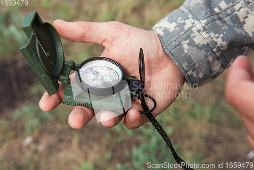 Image of Man with compass in hand outdoor