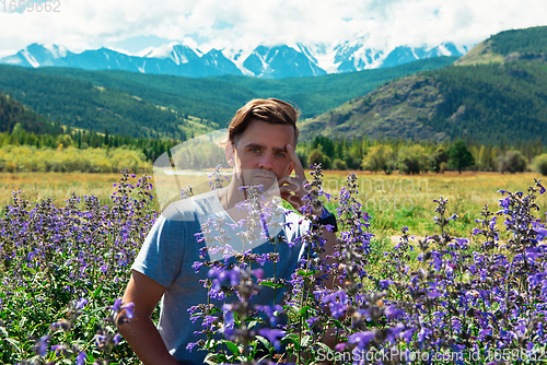 Image of Man in beautiful wild pink and purple flowers field