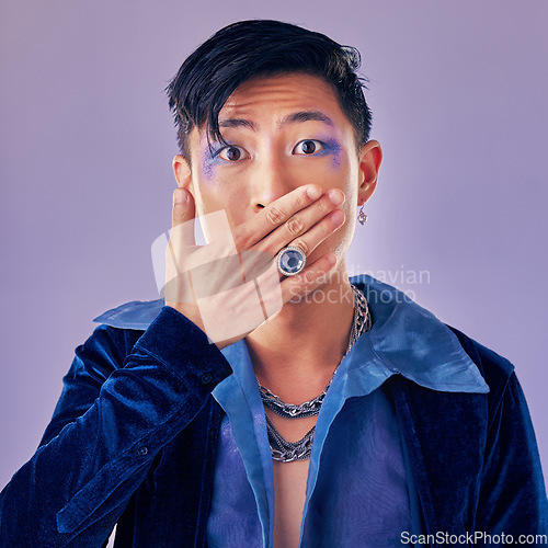 Image of Surprised, shocked and gay man with makeup in a studio for pride, beauty and gender fluid cosmetics. Lgbtq, queer and homosexual guy with wow, surprise or omg expression isolated by purple background