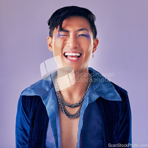 Image of Punk, rock and makeup of a man with a smile for metal music, lifestyle and identity against a purple studio background. Freedom, crazy and face portrait of a cyberpunk Asian person with cosmetics