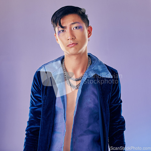 Image of Asian man, makeup and punk fashion for portrait in studio with cyberpunk, creative or aesthetic face. Futuristic model, metal jewellery or clothes with art, cosmetic or beauty by lavender background