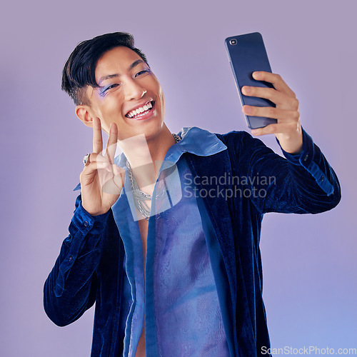 Image of Man, makeup art and selfie with phone for creative, skin or beauty with happiness against purple backdrop. Happy, model and photo with smartphone with face, cosmetic or fashion by lavender background