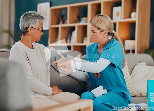 Image of Healthcare, blood pressure and woman with doctor, home test on sofa or doctors visit in apartment living room. Senior care, nurse or caregiver with patient, trust and support in medical house call.