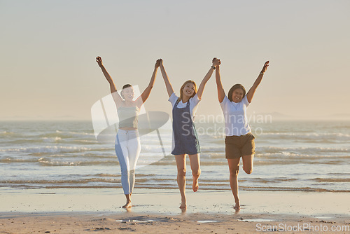 Image of Holding hands, friends and women on beach, jump together and bonding or loving outdoor on summer vacation. Travel, young females or ladies enjoy seaside holiday, for girls trip and connect on break.