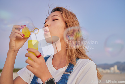 Image of Asian summer, woman with bubbles and blow liquid soap with lips in outdoor nature freedom with beauty face. Young girl playing with party toy, fun magic on beach mockup and blonde hair in Seoul wind