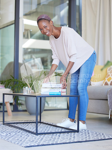 Image of Black woman, books and portrait of student in living room pick up book or business startup guide for reading. Learning, education and female from Nigeria with textbook on table in home for studying.