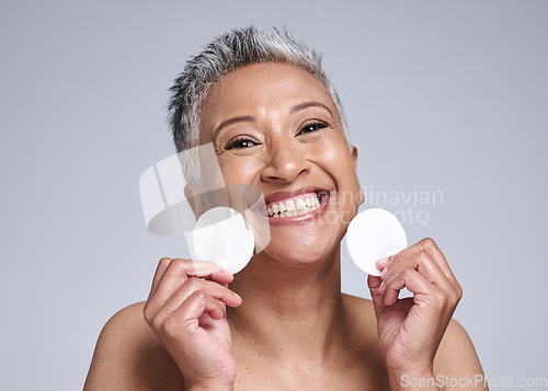 Image of Skincare, portrait and senior woman with cotton pad for natural, anti aging and beauty routine. Cosmetic, health and face of happy elderly lady with skin treatment isolated by gray studio background.