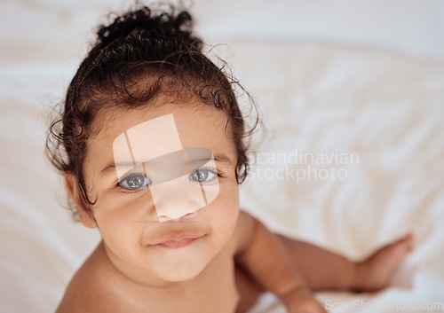 Image of Face, baby and portrait with a newborn infant girl sitting in a cot or crib in the bedroom of her home from above. Children, innocent and cute with an adorable little female kid in her house closeup