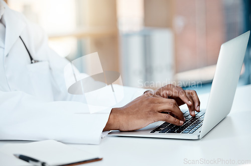 Image of Doctor, hands and typing on laptop in office, working on research or online consultation. Healthcare, computer and black male physician writing patient report, data record or checking medical email.