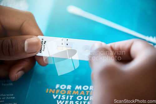 Image of Covid, antigen test and hand of a patient looking at test results for coronavirus illness and reading pamphlet. Analyse, medical exam and covid19 antibody test on a pcr device for a sick person