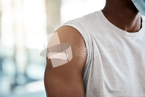 Image of Black man, covid vaccine and plaster on arm for safety, healthcare and prevention or government compliance for health and wellness. Bandaid, first aid and patient injection for covid 19 virus