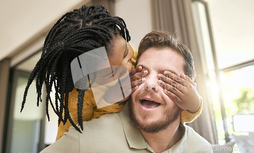 Image of Family, children and adoption with a peekaboo girl and foster father playing together in the living room of their home. Love, kids and game while a female child surprise her dad in a playful moment