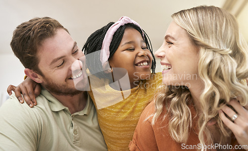 Image of Family diversity and adoption with a foster mother, father and girl bonding in the living room of their home. Trust, love and smile with a man, woman and daughter happy together in their house