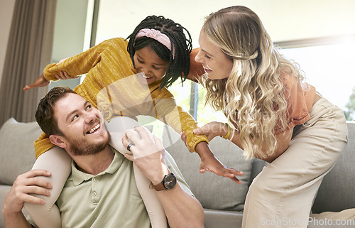 Image of Bonding, diversity and child with parents in foster care for love, happy and safety in a family home. Playful, smile and father, mother and African girl playing in an interracial house after adoption