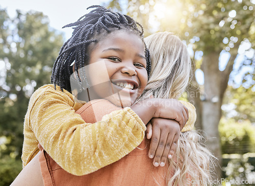 Image of Mother, interracial adoption and carry girl in park in summer sunshine, happiness and love outdoor. Happy black child, white mom and hug together in nature with smile, embrace and care with diversity