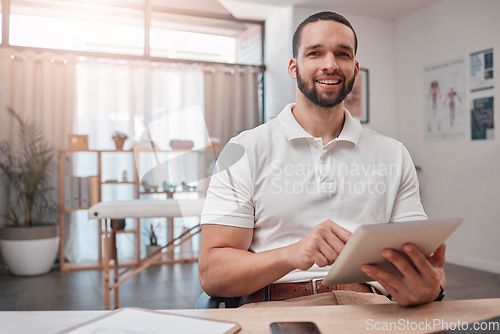 Image of Tablet, physiotherapy and healthcare with a man doing research online in his rehabilitation office. Portrait, recovery and treatment with a male therapist doing an internet search for sports rehab