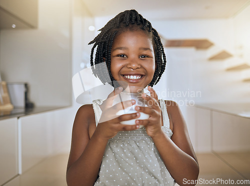 Image of Child, happy and healthy milk drink for energy vitamins or health wellness at home. Black girl portrait, glass and drinking dairy breakfast or calcium nutrition for kids teeth health care in kitchen