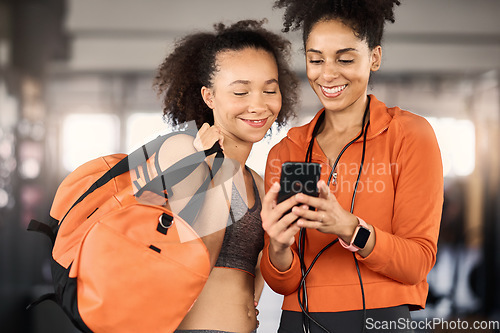 Image of Gym, friends and women with phone, fitness app and planning workout schedule or checking training progress. Exercise, friendship and smartphone, black woman and personal trainer checking social media