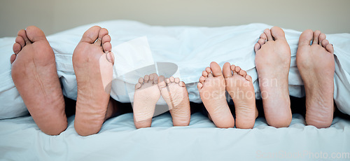 Image of Family, feet and bed in morning for relax, calm and sleeping in bedroom together. Mother, father and young child resting in morning, dreaming and weekend nap or relaxing holiday in family home