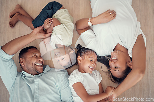 Image of Top view, happy family or bonding on floor in house living room, family home bedroom or Indonesian hotel. Smile, children or kids with mother, father or parents lying on ground in trust, play or love