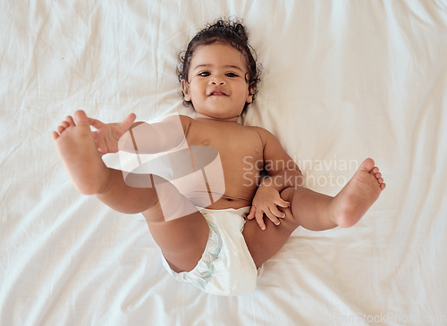 Image of Happy, smile and portrait of a baby with a diaper relaxing on a bed in his bedroom or nursery. Happiness, health and toddler kid by with a disposable nappy laying and relaxing in room at family home.