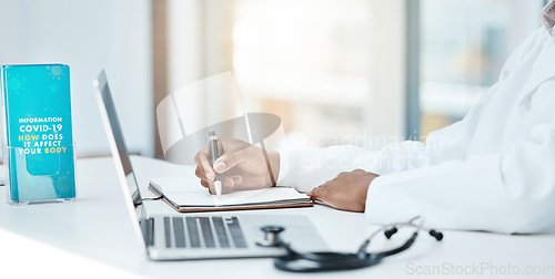 Image of Covid, laptop and writing with a doctor working on research in an office in the hospital for cure or treatment. Computer, notebook and healthcare with a medicine professional working on medical care