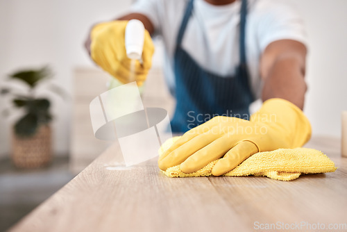 Image of Black man, hands and spray bottle and cleaning cloth on house table, home desk or office building counter top. Zoom, gloves and fabric bacteria product for hygiene maintenance and healthcare wellness