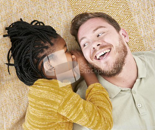 Image of Happy, whisper secret and child in an interracial family with father with a smile about adoption above. Dad, girl and kid care of a man with happiness, love and parent care on a home carpet bonding