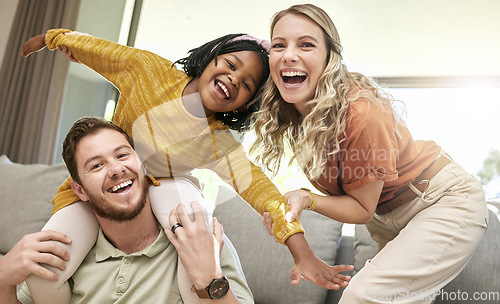 Image of Adoption, love and portrait of family on sofa laughing, smiling and having fun together. Happiness, bonding and multicultural happy family at home with young daughter playing with foster parents