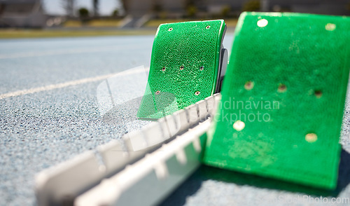 Image of Sports closeup, starting blocks and running track, field or pitch for training, exercise or sprint in arena. Start, ready and race with equipment for sport, fitness or workout on ground at stadium