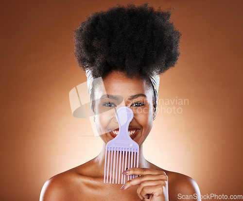 Image of Comb, black woman and hair care with smile, afro and natural beauty for health against brown studio background. Cosmetics portrait, hair product and African American female being happy, confident