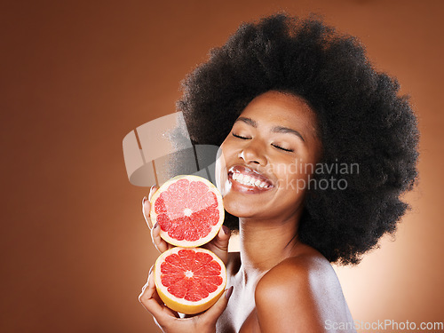 Image of Black woman, afro hair or grapefruit for face skincare, healthcare wellness glow or vitamin c dermatology routine. Smile, happy or beauty model with natural hair, citrus food or vegan facial product