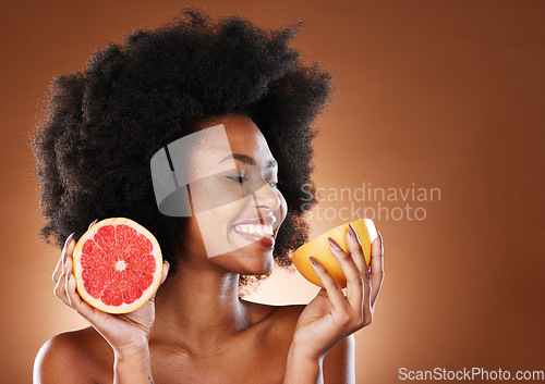 Image of Grapefruit, black woman and vitamin c beauty, skincare and wellness, healthy body or aesthetics, natural cosmetics and afro on studio background. Happy young african model eating citrus for nutrition