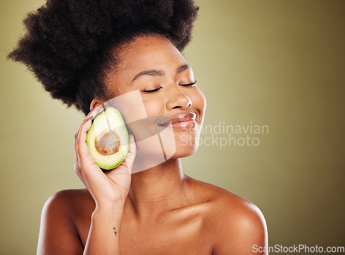 Image of Face, skincare and black woman with avocado for health, wellness and nutrition on green background. Eyes closed, healthy food and antioxidant diet of happy female model from Nigeria with glowing skin