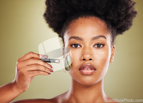 Image of Skincare, face roller and black woman in studio portrait with facial massage for natural beauty, cosmetics and facial wellness product. African beauty model with stone rose quartz in dermatology care