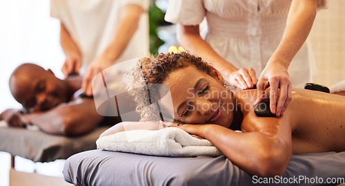 Image of Spa, wellness and massage for couple and hot stone therapy, massage therapist hands for stress relief and body health. Man and woman relax with luxury service at beauty salon, peace and detox release