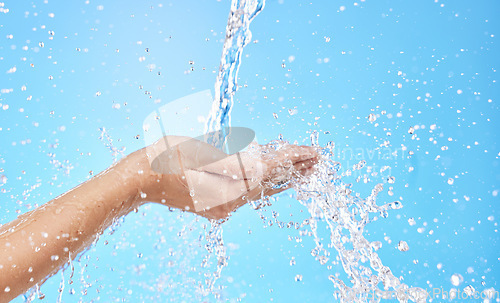 Image of Hands, water splash and cleaning skin, bacteria and hygiene for blue studio background with mockup space. Hand rinsing, washing or clean for fresh hygienic cleanse or hydration in care for skincare