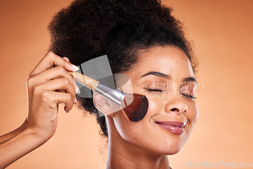 Image of Face, beauty and blusher with a black woman model in studio on a beige background to apply blush to her cheek. Makeup, cosmetics and luxury with an attractive young female using a product on her skin