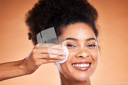 Image of Black woman, beauty and swab for makeup removal in skincare against a studio background. Portrait of African American female model smile removing facial cosmetics in satisfaction for skin treatment