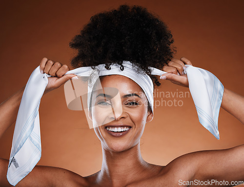 Image of Black woman, hair scarf and hairstyle with portrait of aesthetic female tying her curly style on a brown studio background. Afro style, haircare routine and a lady with hair wrap for healthy hair