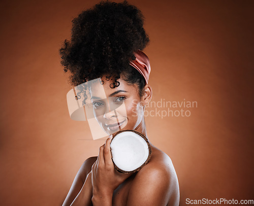 Image of Woman, coconut fruit and body skincare glow on studio background for organic hydration, vegan moisture or holistic dermatology. Portrait, smile and happy african beauty model with coco butter product