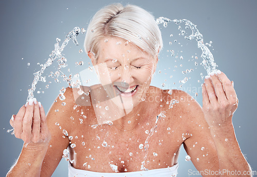 Image of Mature woman, water splash or washing face in skincare grooming routine, morning hygiene maintenance or healthcare wellness. Smile, happy or elderly beauty model in facial cleaning and wet water drop