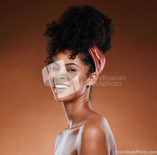 Image of Hair care, skincare and black woman with a smile for beauty against a brown studio background. Wellness, happy and portrait of an African girl model with makeup, cosmetics and routine grooming