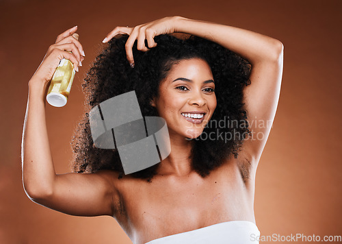 Image of Haircare, beauty and black woman with hairspray on afro for health, wellness and shine for natural curly hair . Cosmetics, hairsalon and female model with products on brown background studio