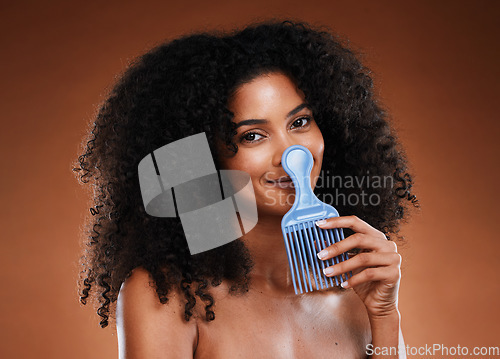 Image of Curly hair comb, beauty and black woman with afro hairstyle, cosmetics and perm on studio background. Portrait happy young african girl, hair brush and natural hair care, fashion and funky hair style