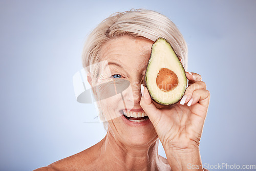 Image of Skincare, avocado and senior woman with smile, natural beauty and confident against grey studio background. Cosmetics, mature female and elderly lady with avo for facial oils for wellness and health