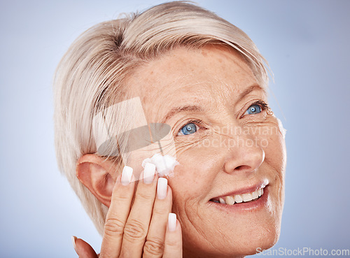 Image of Skincare, thinking and senior woman with cream for face against a grey studio background. Sunscreen, happy and elderly model with an idea with a facial dermatology product for beauty and self care