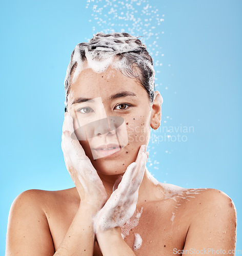 Image of Shower, shampoo and hair care, woman with soap and clean portrait for grooming and hygiene against blue studio background. Face, hands and wellness with washing hair and beauty with water droplets.