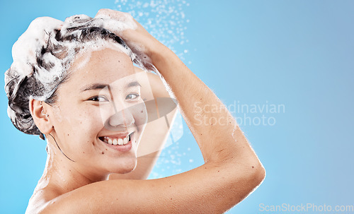 Image of Water, shampoo and woman in shower on blue background, haircare and hygiene routine in the morning. Model in shower cleaning hair, soap and foam with running water for clean fresh beauty with mockup